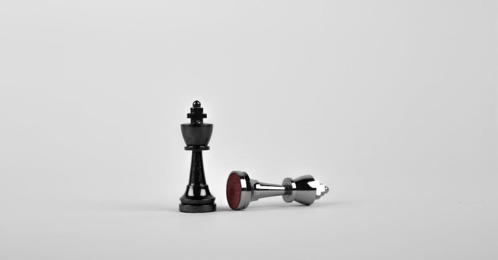Close-up of chess king piece standing with a fallen piece symbolizing strategy and victory.